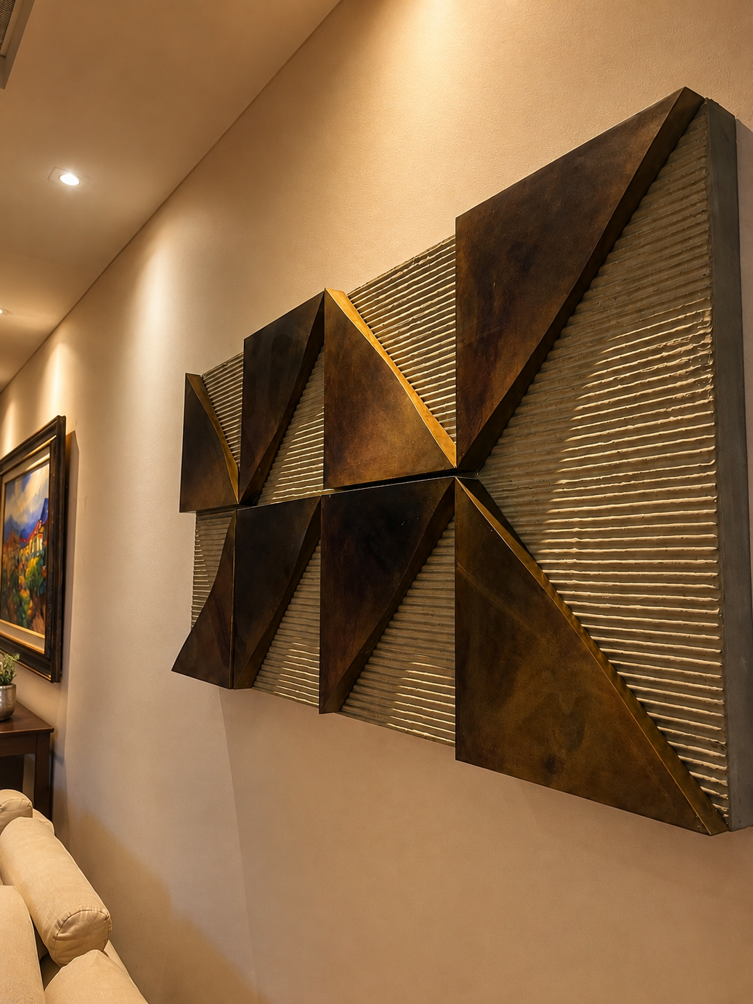 Obra geométrica em metal bronze instalada em sala de estar